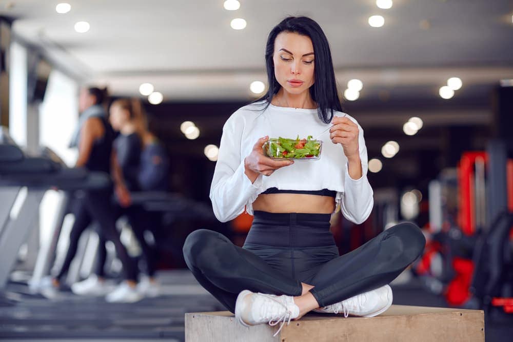 woman eating salad gym